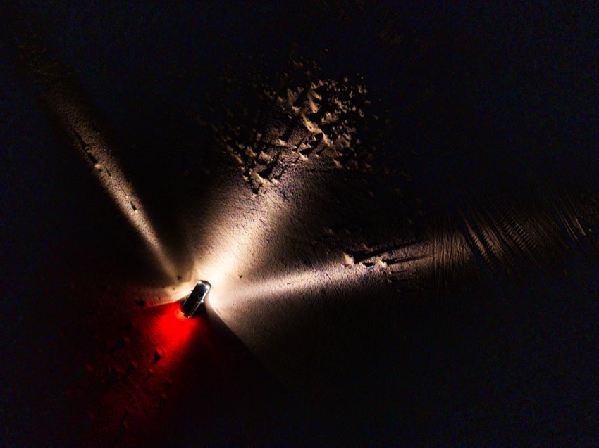 Field researcher working by headlamp in darkness on Saharan sand